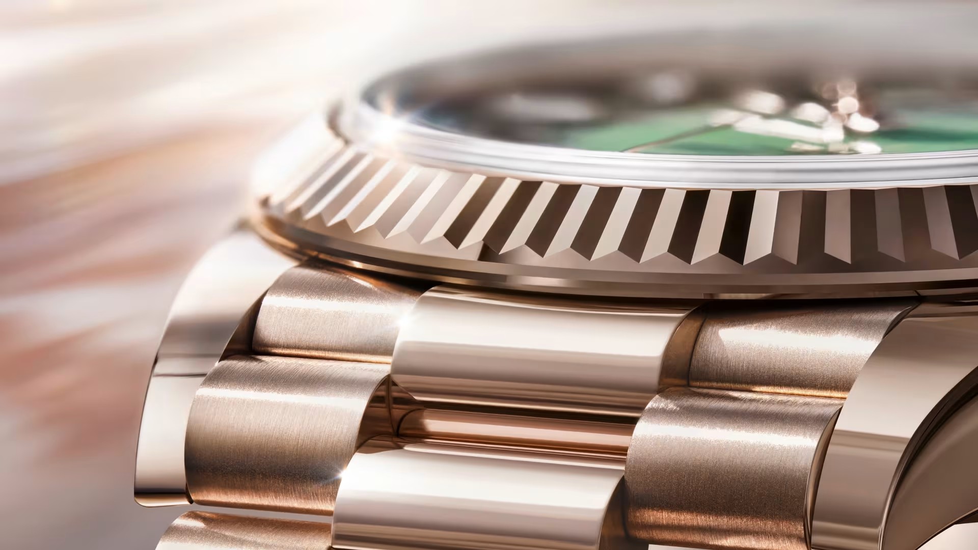 Macro detail of a pale pink-gold alloy watch bezel and bracelet