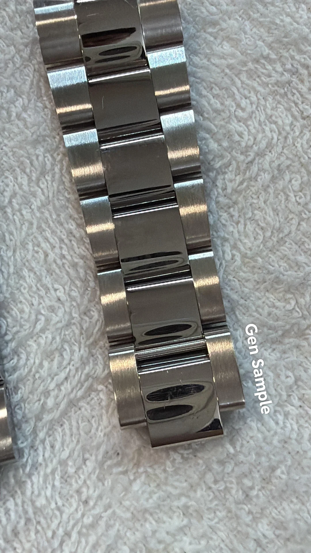 Close-up of a polished white gold bracelet link beside a genuine white gold reference sample