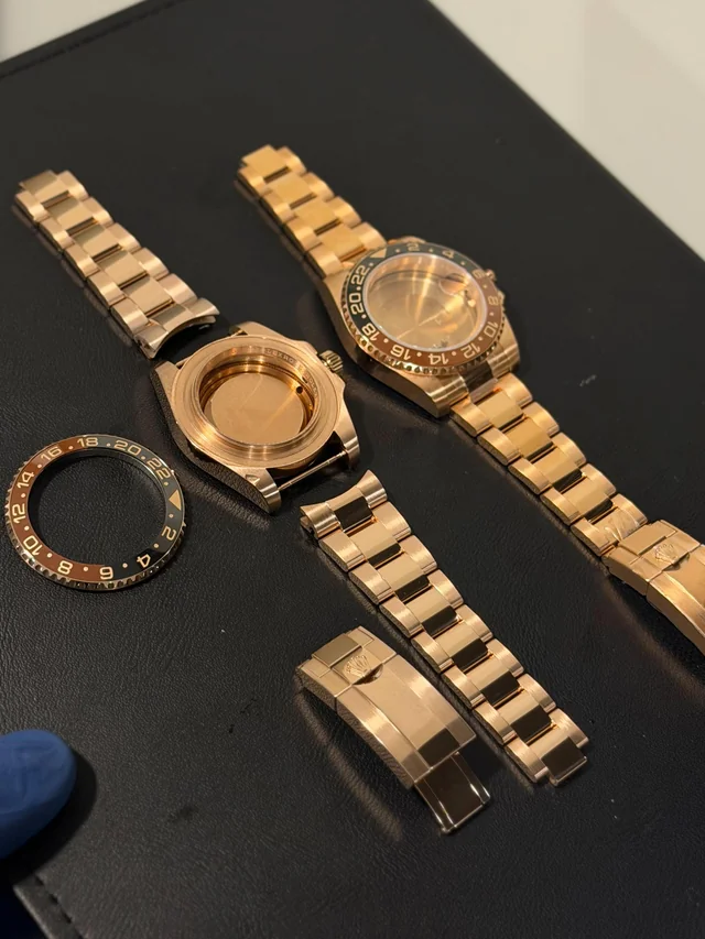 Rose gold GMT watch fully disassembled into case, bracelet, bezel, and clasp for full-component plating