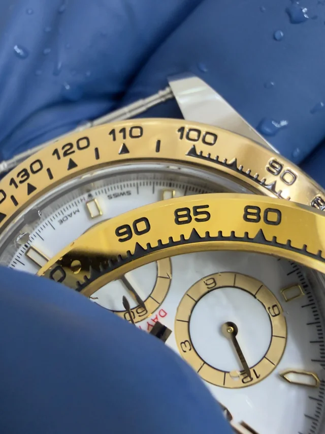 Macro detail of a yellow gold chronograph bezel and dial subdials