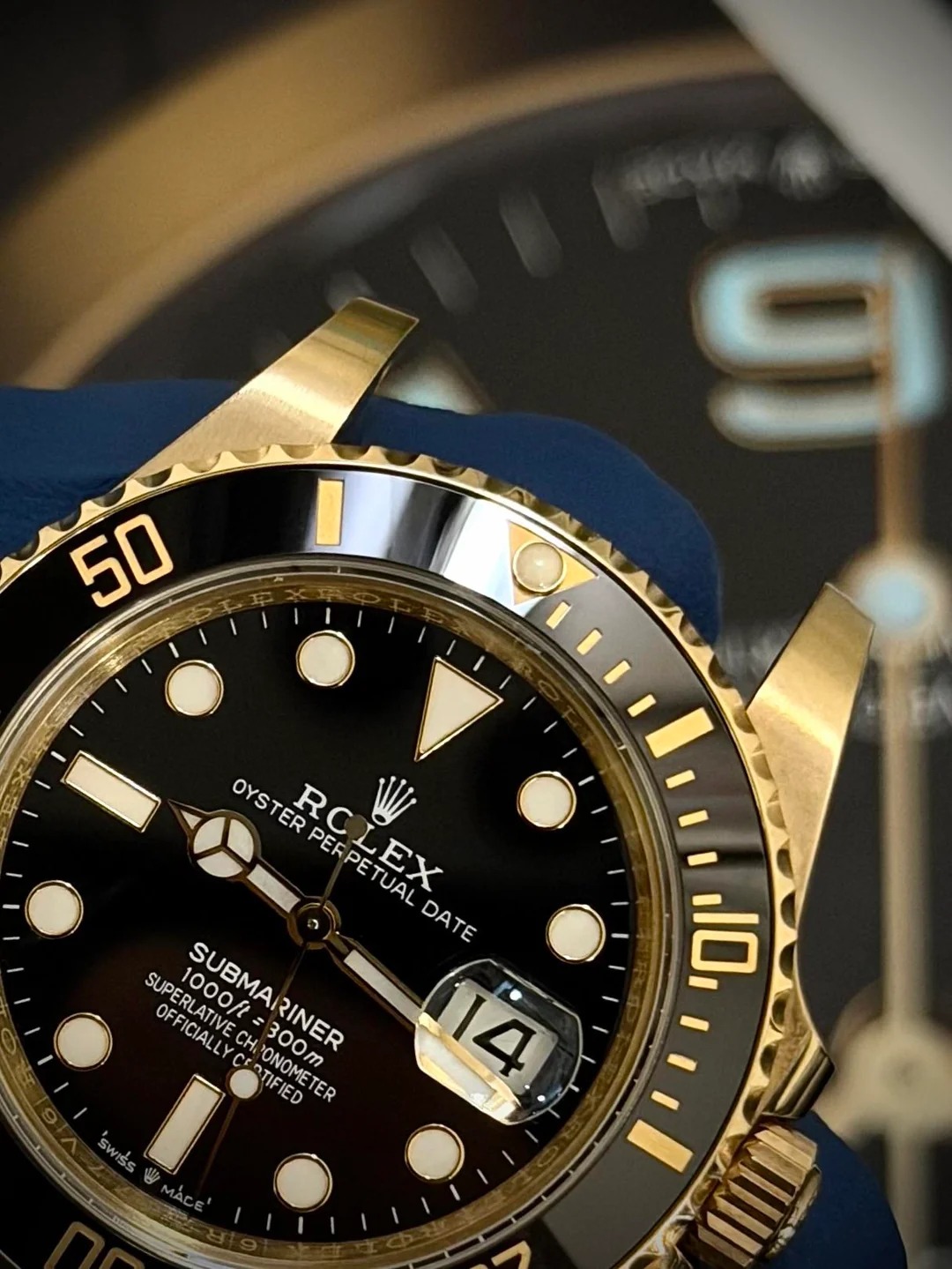 Macro detail of a yellow gold Submariner bezel, dial, and date window